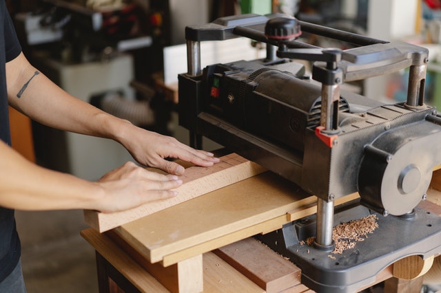 This image shows planer type of machining operation on wood using planer machine.